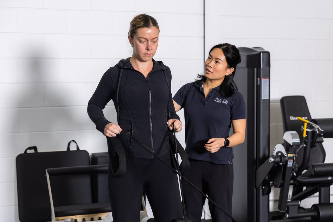 Physiotherapist guiding a client through resistance-band exercise